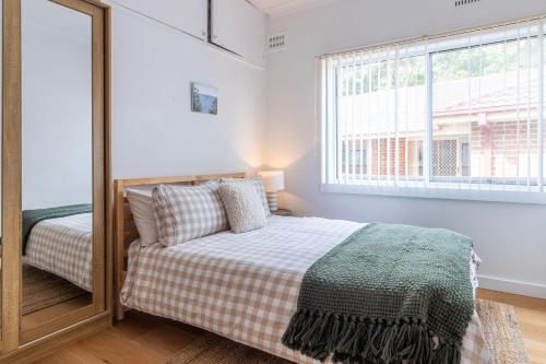 サセックス・インレットにあるSussex Beach Houseのベッドと鏡のある寝室