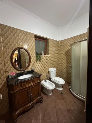 a bathroom with a toilet and a sink and a mirror at Rus Apartment in Berat