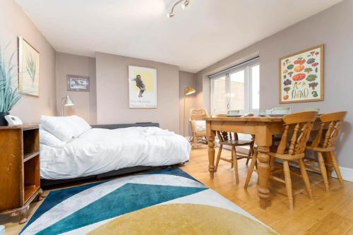 - une chambre avec un lit, une table et des chaises dans l'établissement Garden apartment by the sea, à Brighton et Hove
