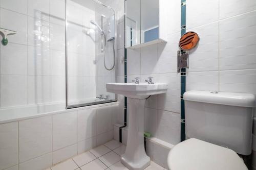 a white bathroom with a toilet and a sink at Quiet & calm apartment with garden in Brighton & Hove