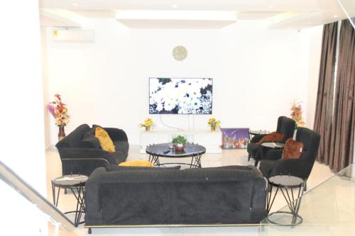 a living room with two couches and a table at Banner Vacation Home & Swimming Pool in Prampram