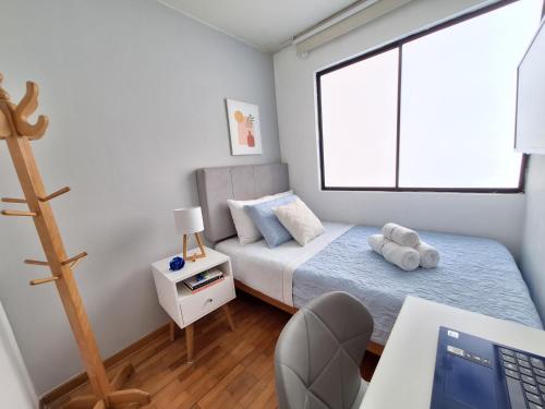 a small bedroom with a bed and a desk at Habitación baño Compartido La Paz 2 in Lima