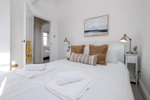 a white bed with two towels on top of it at Beautiful Mews Cottage nr South Downs & Seaside in Rottingdean
