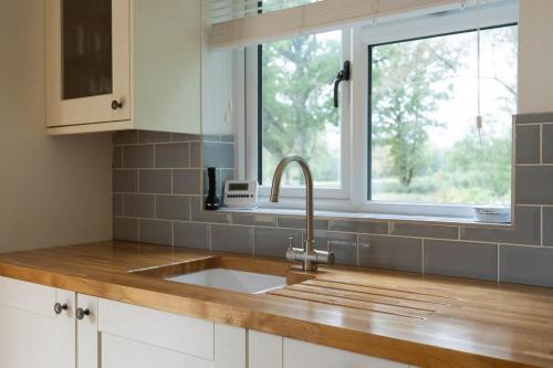 a kitchen with a sink and a window at Countryside Cottage with Stunning Views in Fletching