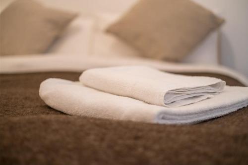 un mucchio di asciugamani bianchi seduti sopra un letto di Palatial 2-Bed Apartment with Outside Space a Brighton & Hove