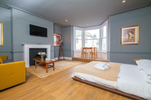 a bedroom with a large bed and a fireplace at Light & Airy Sea View Apartment, Central Brighton in Brighton & Hove