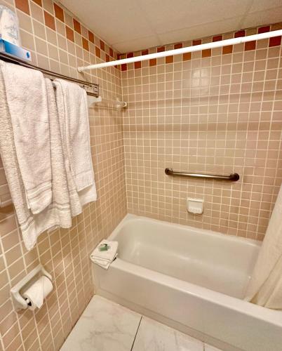 a bathroom with a white bath tub and towels at Hotel Chateaubleau in Miami