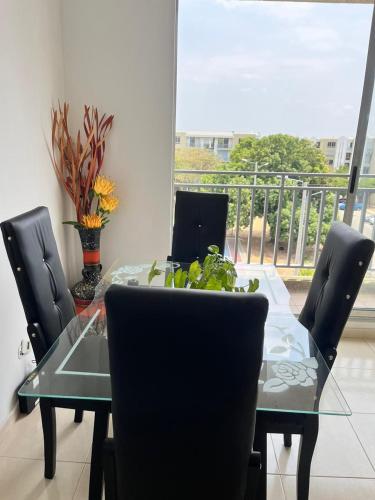 a dining room table with chairs and a table with a plant on it at Lindo Apto con Aire Acond de 3 habitaciones in Valledupar
