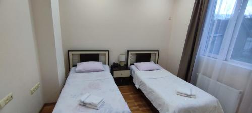 two beds in a small room with two mirrors at Hotel Max Comfort in Kutaisi
