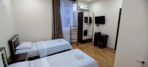 a hotel room with two beds and a mirror at Hotel Max Comfort in Kutaisi