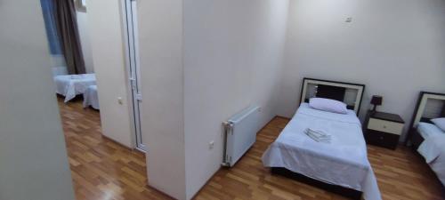 a small room with a bed and a refrigerator at Hotel Max Comfort in Kutaisi