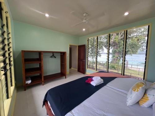 a bedroom with a large bed with a large window at Lapita Beach Aore Island Vanuatu in Luganville