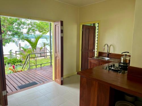 a kitchen with a sliding glass door to a deck at Lapita Beach Aore Island Vanuatu in Luganville