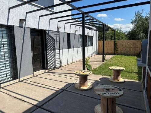 un patio con 2 taburetes y una pérgola en Alquiler Vivienda Completa en Barrio Residencial, en Buena Nueva