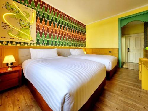 a hotel room with two beds and a painting on the wall at Senglao Boutique Hotel Luang Prabang in Luang Prabang