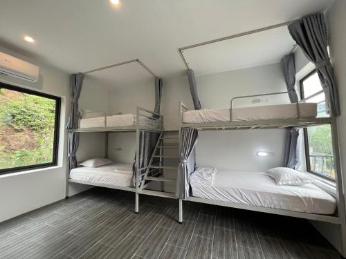 河江的住宿－LiLa Inn & Motorbike Tours Ha Giang，带窗户的客房内的两张双层床