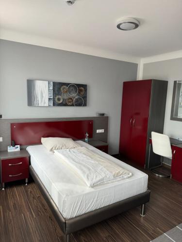 a bedroom with a bed with a red headboard at Ariston Hotel in Sindelfingen