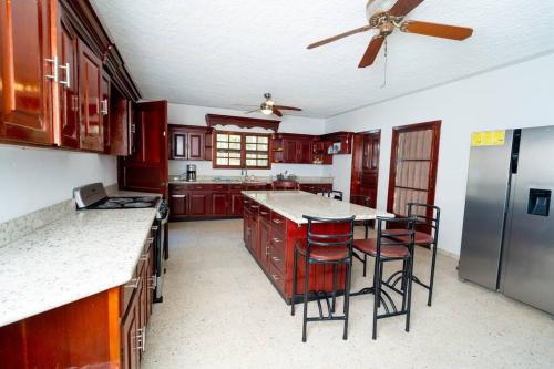 eine Küche mit roten Schränken und einem Deckenventilator in der Unterkunft Casa Luna Azul in La Ceiba