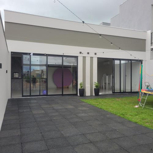 a large building with glass doors and a lawn at Happy Buritis, eventos e hospedagem in Primavera do Leste