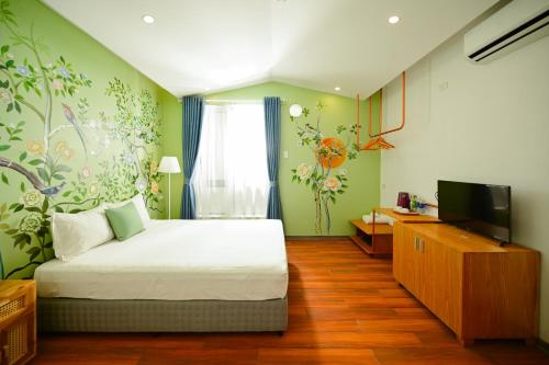 a bedroom with a bed and a tv in it at Eden Home&Cafe in Quy Nhon