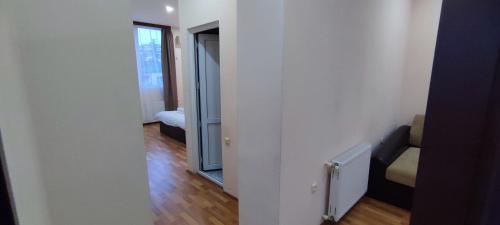 a room with a hallway with a couch and a mirror at Hotel Max Comfort in Kutaisi