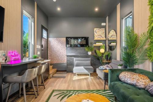 a living room with a green couch and a bar at Dome House YYC, Iconic, Luxury, Backyard Oasis in Calgary