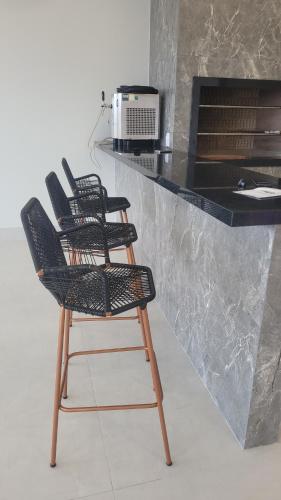 two chairs sitting at a counter in a kitchen at Happy Buritis, eventos e hospedagem in Primavera do Leste