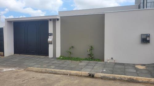 a garage with a blue door on a building at Happy Buritis, eventos e hospedagem in Primavera do Leste