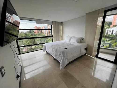 a bedroom with a white bed and a large window at 401 Luxury apartment in hearth of El Poblado + View! in Medellín