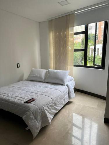 a bed in a room with a large window at 401 Luxury apartment in hearth of El Poblado + View! in Medellín