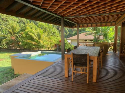 una terrazza con tavolo, sedie e piscina di VILLA TEPUA a aUturoa