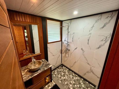 bagno con lavandino e doccia con bancone di VILLA TEPUA a aUturoa
