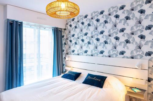- une chambre avec un lit et un mur avec une grande fenêtre dans l'établissement Plage à pied - Parking - T2 spacieux et balcon, à La Baule