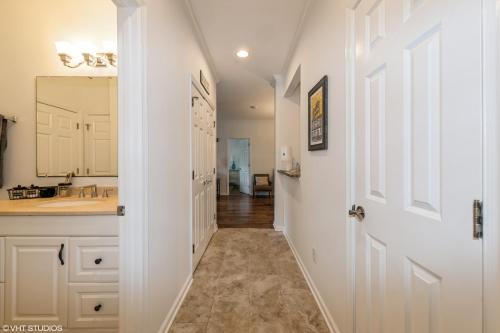 a hallway leading to a bathroom with a sink and a mirror at Comfy, Convenient Close to Rehoboth and Lewes! in Rehoboth Beach