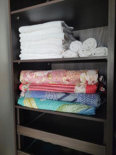 a shelf filled with towels and folded towels at Casa agradável com área gourmet in Ji-Paraná