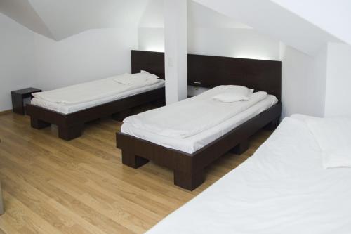 two beds in a room with white walls and wooden floors at Villa Grande in Iaşi