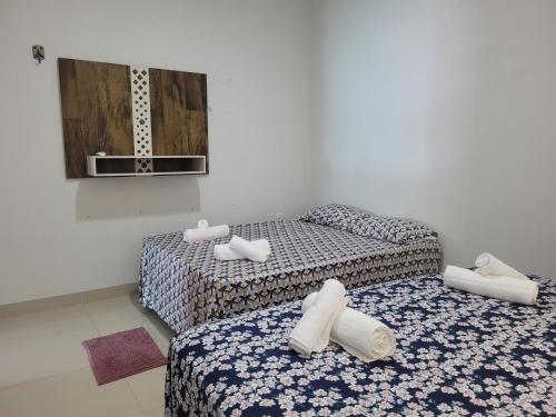 2 Betten in einem Zimmer mit Handtüchern darauf in der Unterkunft Casa agradável com área gourmet in Ji-Paraná