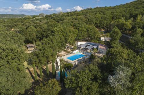 - une vue aérienne sur une demeure de caractère dotée d'une piscine et d'arbres dans l'établissement Slow Village La Roque Sur Cèze, à La Roque-sur-Cèze