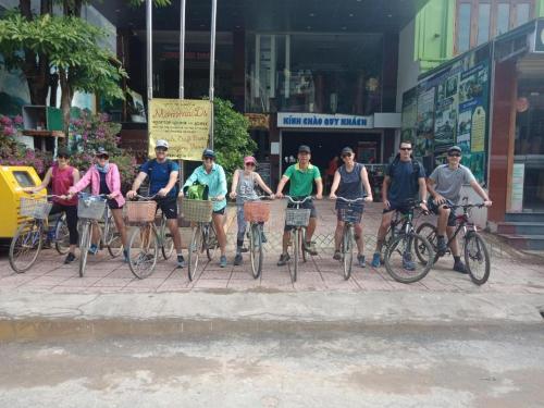 a group of people riding bikes on a street at Phong Nha Jasmine Hostel & Roof Top Bar in Phong Nha