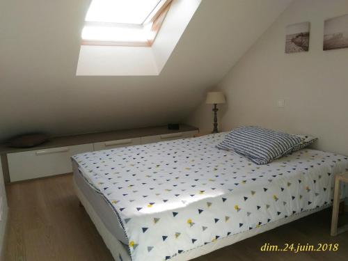 une chambre avec un lit et une lucarne dans l'établissement Maison rénovée près de la plage avec jardinet et wifi - FR-1-485-4, à Les Sables-dʼOlonne