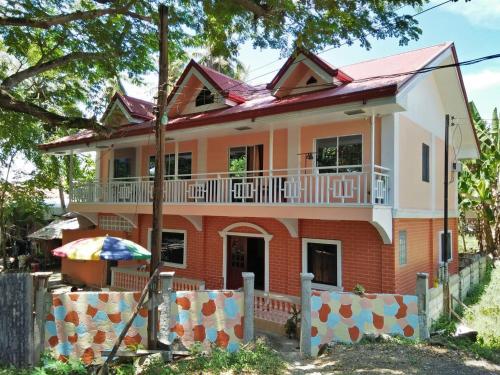 a large house with a balcony on top of it at TGH Guest House Badian in Badian