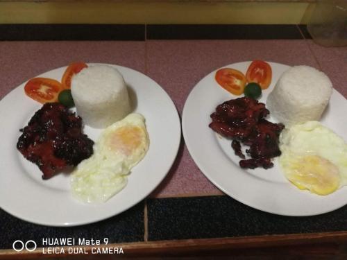 two plates of food with eggs and tomatoes on them at TGH Guest House Badian in Badian