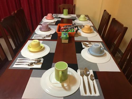 a long table with hats and plates and utensils at TGH Guest House Badian in Badian