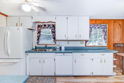 a kitchen with white cabinets and a refrigerator at Beech Retreat in Inverness