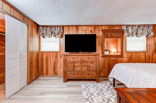 a bedroom with a bed and a television on a wooden wall at Beech Retreat in Inverness