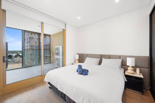 a bedroom with a large bed and a large window at SOP 99 Modern 3 Bedroom with Pool & Free Parking in Sydney