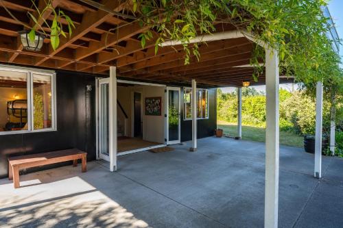 a covered patio with a bench and a table at Close to the Lake in Taupo