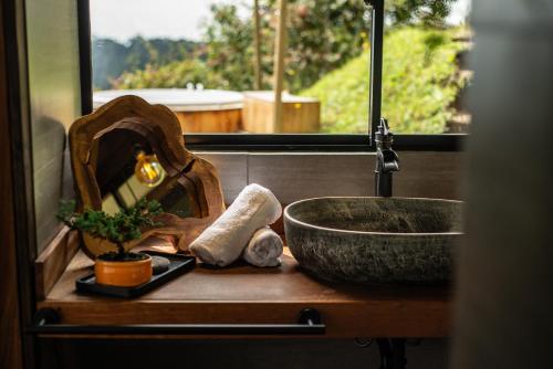 eine Badezimmertheke mit einem Waschbecken und einer Schüssel in der Unterkunft Owl's Watch Nature Retreat in Manizales