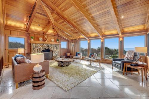 un grand salon avec cheminée et plafonds en bois dans l'établissement Perched on the Bluff - Main Home & Studio Cottage, à Mendocino