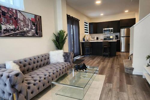 a living room with a couch and a glass table at Comfortable entire townhouse in downtown Edmonton. in Edmonton